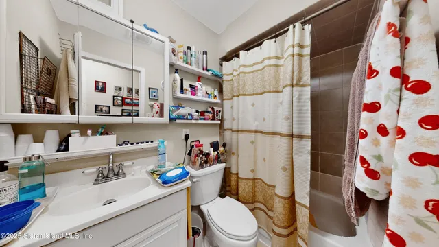 a bathroom with a sink toilet and shower curtain
