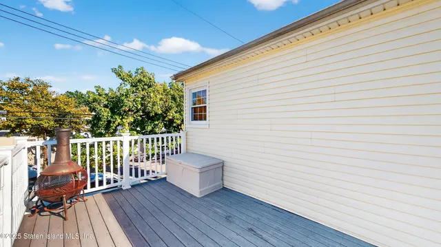 a view of a patio with table and chairs potted plants and floor to ceiling window