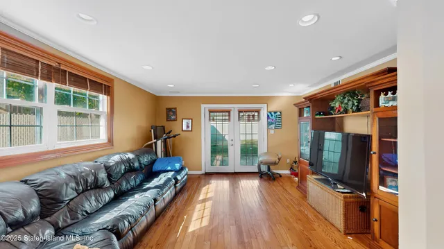 a living room with furniture floor to ceiling window and a flat screen tv
