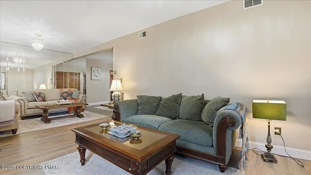 a living room with couches and kitchen view