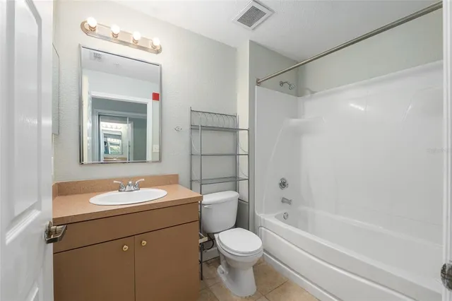 a bathroom with a granite countertop sink toilet a mirror and shower