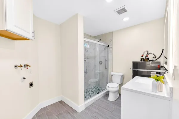 a bathroom with a sink a toilet and shower