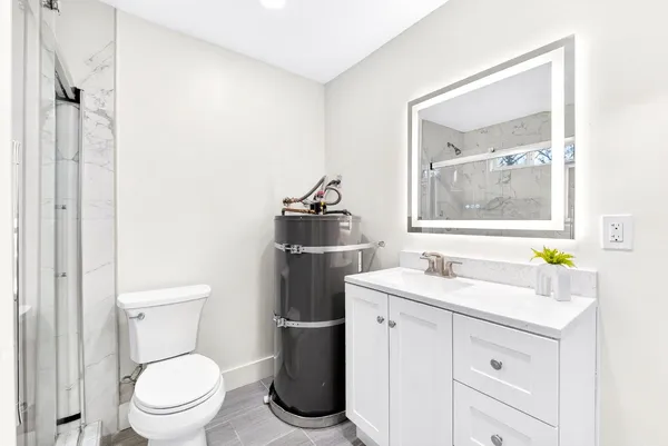 a bathroom with a toilet sink vanity and mirror