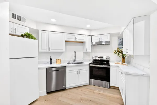 a kitchen with a stove top oven sink and white cabinets