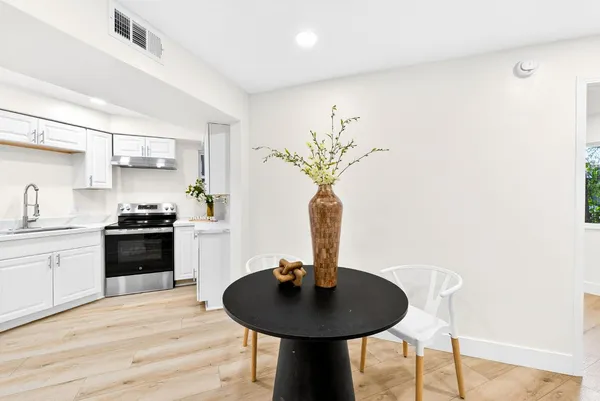 a kitchen with stainless steel appliances a table and a sink