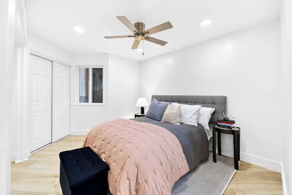 a bedroom with a bed and a ceiling fan