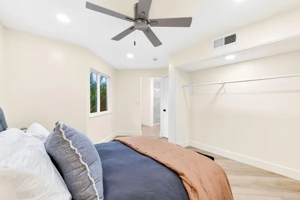 a bedroom with a bed chandelier and a window