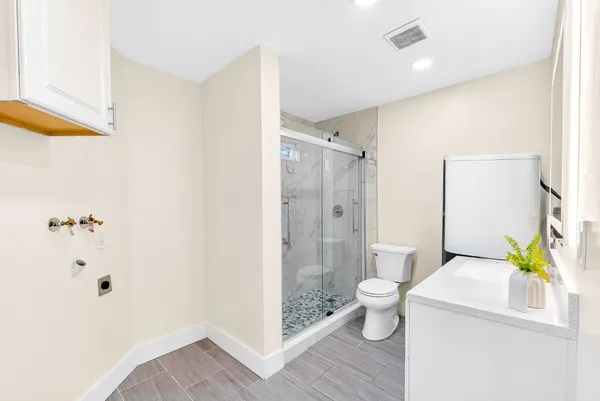 a bathroom with a sink a toilet and shower