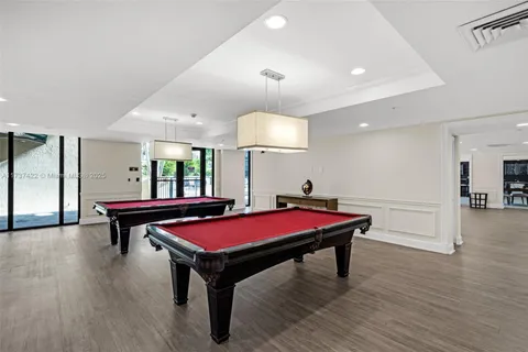 a room with pool table and wooden floor