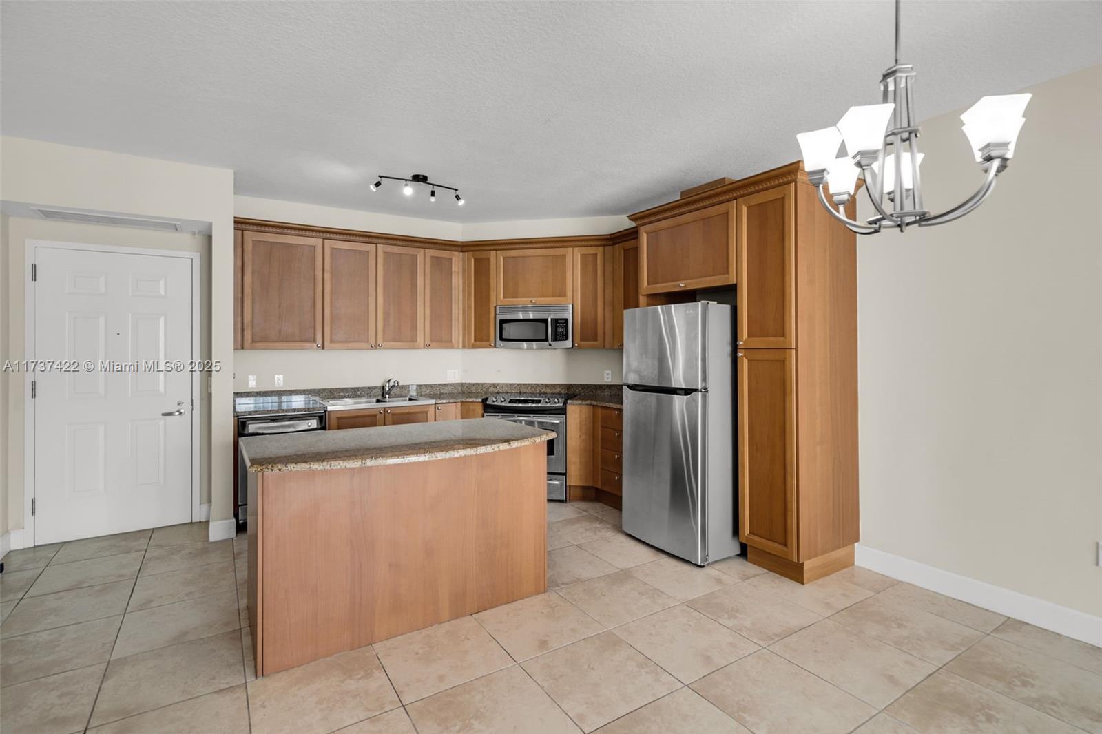 55 Merrick Way, Unit 624 Coral Gables, FL 33134 - Photo 4 of 41 a kitchen with stainless steel appliances granite countertop a refrigerator a stove a sink dishwasher and a refrigerator with wooden floor