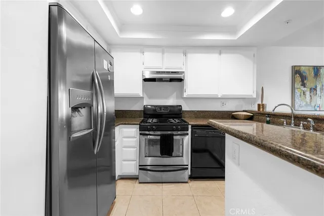 a kitchen with stainless steel appliances granite countertop a stove and a refrigerator