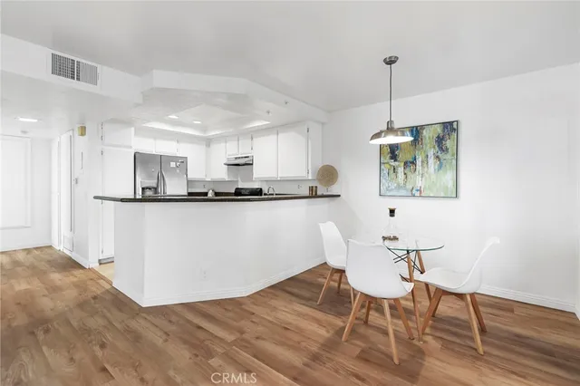 a kitchen with stainless steel appliances granite countertop a kitchen island a stove a table and chairs