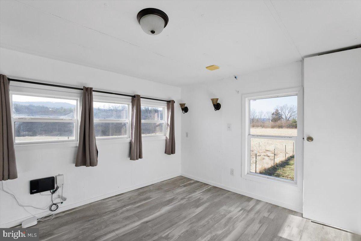 244 Muddy Road Augusta, WV 26704 - Photo 22 of 33 a view of an empty room with wooden floor and windows