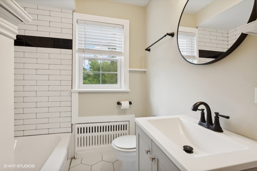 338 Ridge Avenue, Unit 3 Evanston, IL 60202 - Photo 25 of 29 a bathroom with a sink a toilet and a mirror