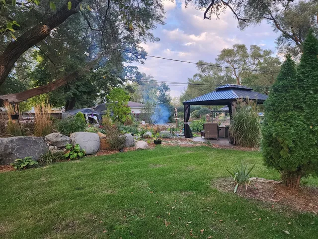 a view of a house with a backyard and sitting area