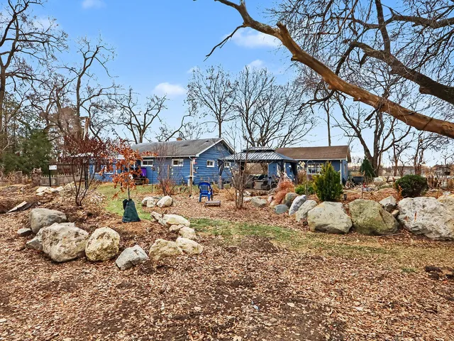 a view of a chairs and fire pit in the middle of a yard