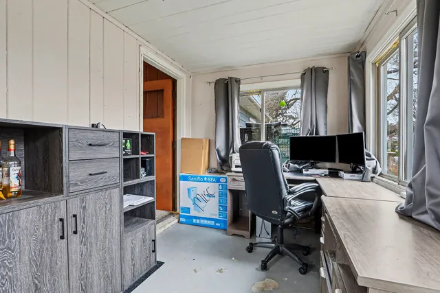 a view of a workspace with furniture and a window