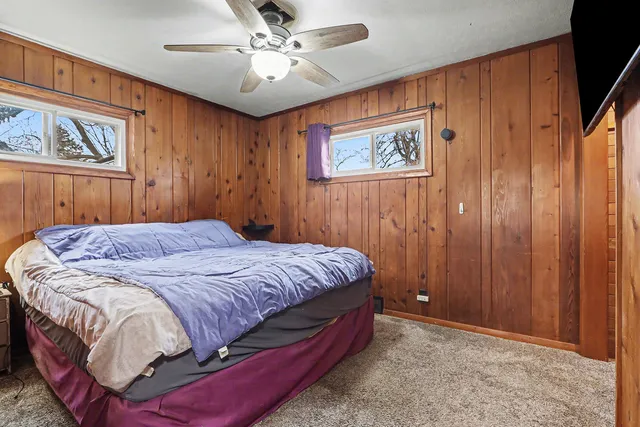 a bed sitting in a spacious bedroom next to a window