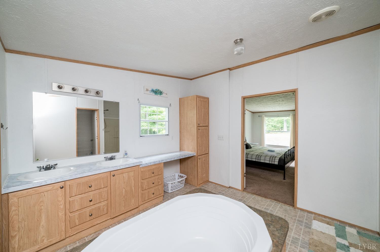 502 Blue Ridge Lane Monroe, VA 24574 - Photo 24 of 43 a spacious en suite bathroom with a double sink and mirror