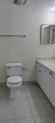 a white toilet sitting next to a bathroom sink