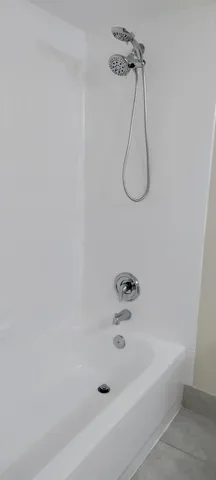 a bathroom with a bath tub with a shower