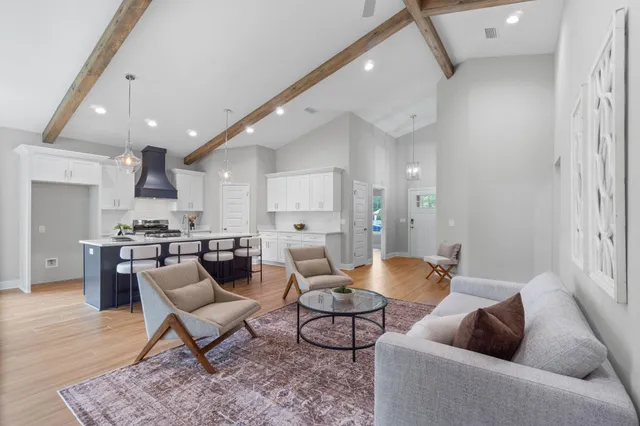 a living room with furniture and a view of kitchen