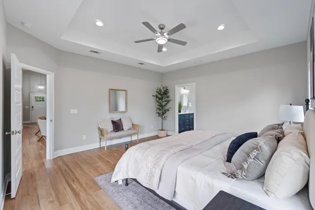 a bedroom with a large bed and a chandelier