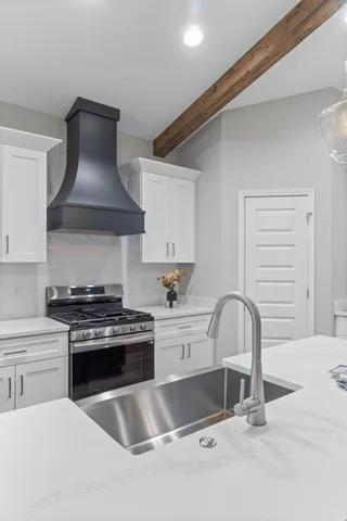 a kitchen with granite countertop a stove a sink and a granite counter tops