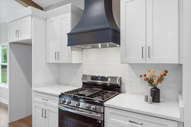 a kitchen with white cabinets and appliances