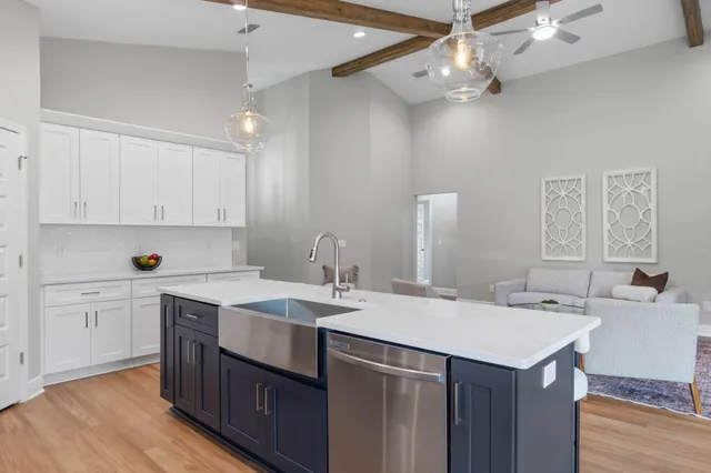 a kitchen with a sink a stove a refrigerator and white cabinets