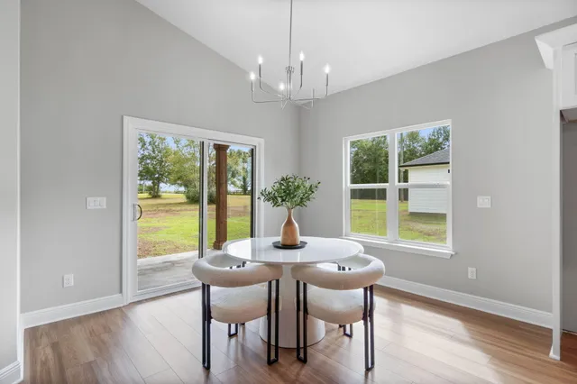 a dining room with furniture a chandelier and wooden floor