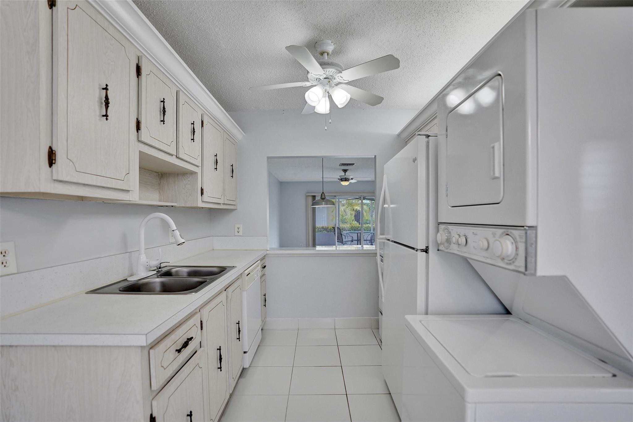 2380 Malayan Drive, Unit B Delray Beach, FL 33445 - Photo 12 of 35 a kitchen with white cabinets and window