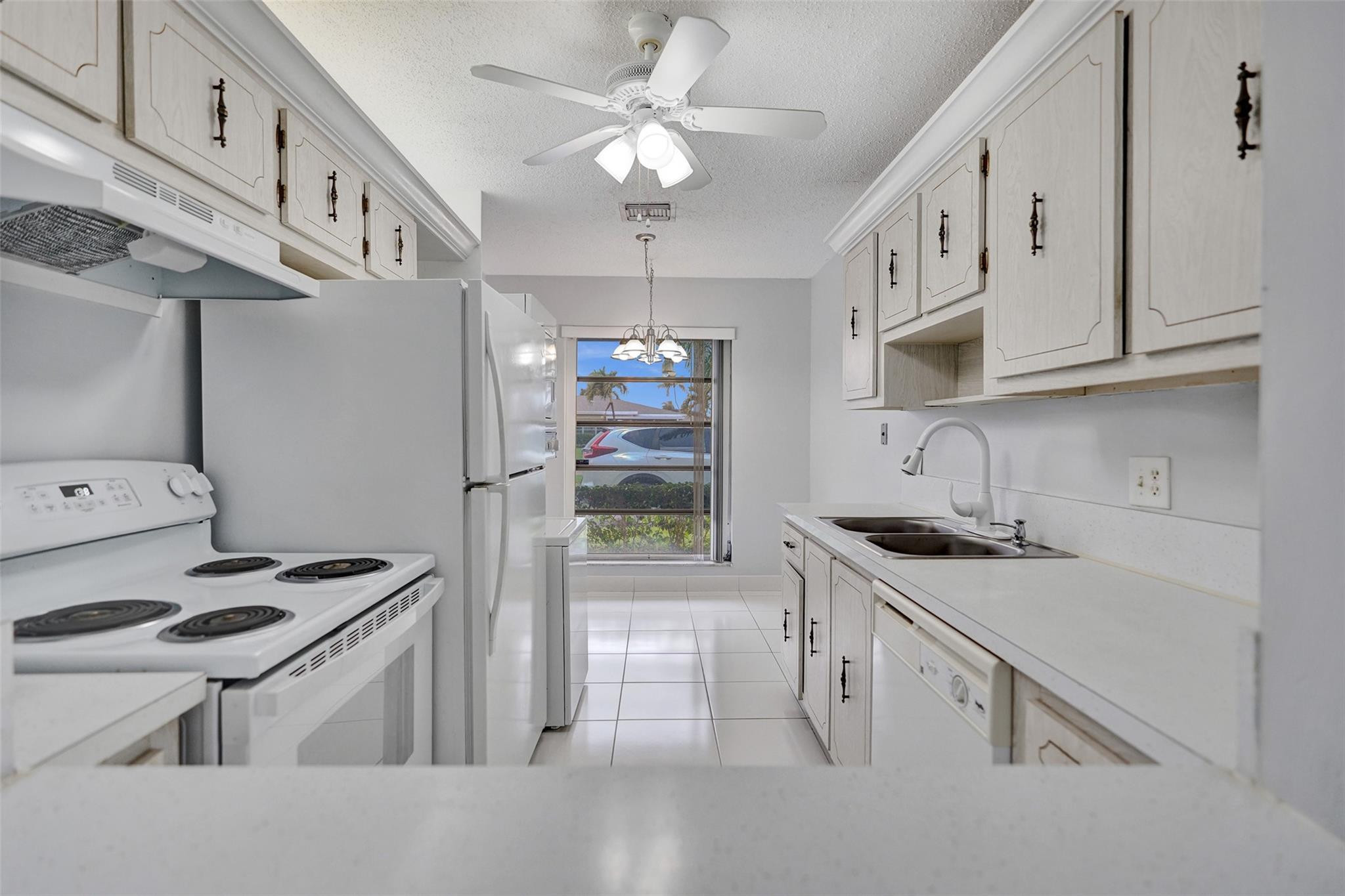 2380 Malayan Drive, Unit B Delray Beach, FL 33445 - Photo 15 of 35 a kitchen with stainless steel appliances a stove a sink and a refrigerator