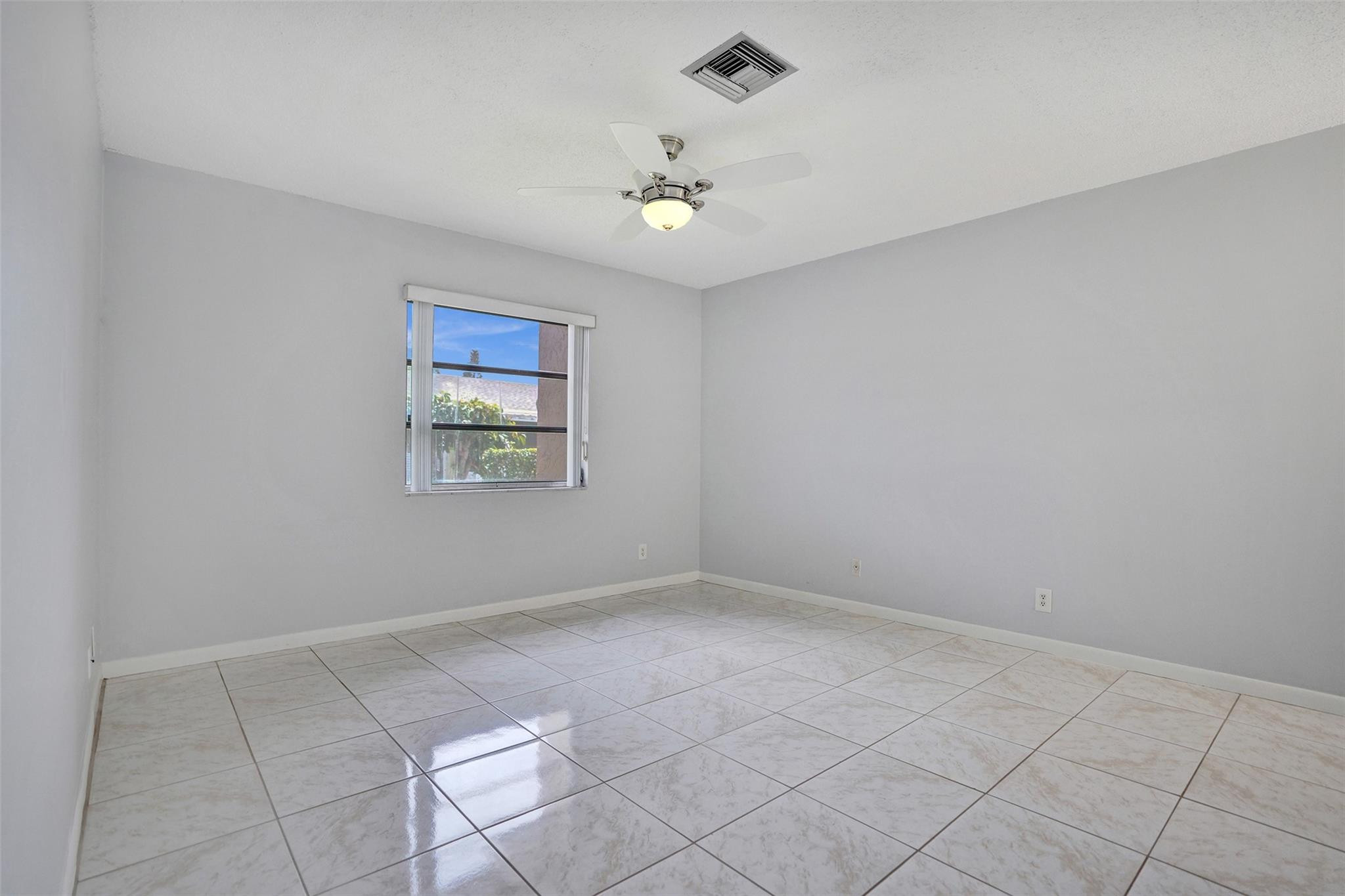 2380 Malayan Drive, Unit B Delray Beach, FL 33445 - Photo 22 of 35 an empty room with windows and ceiling fan