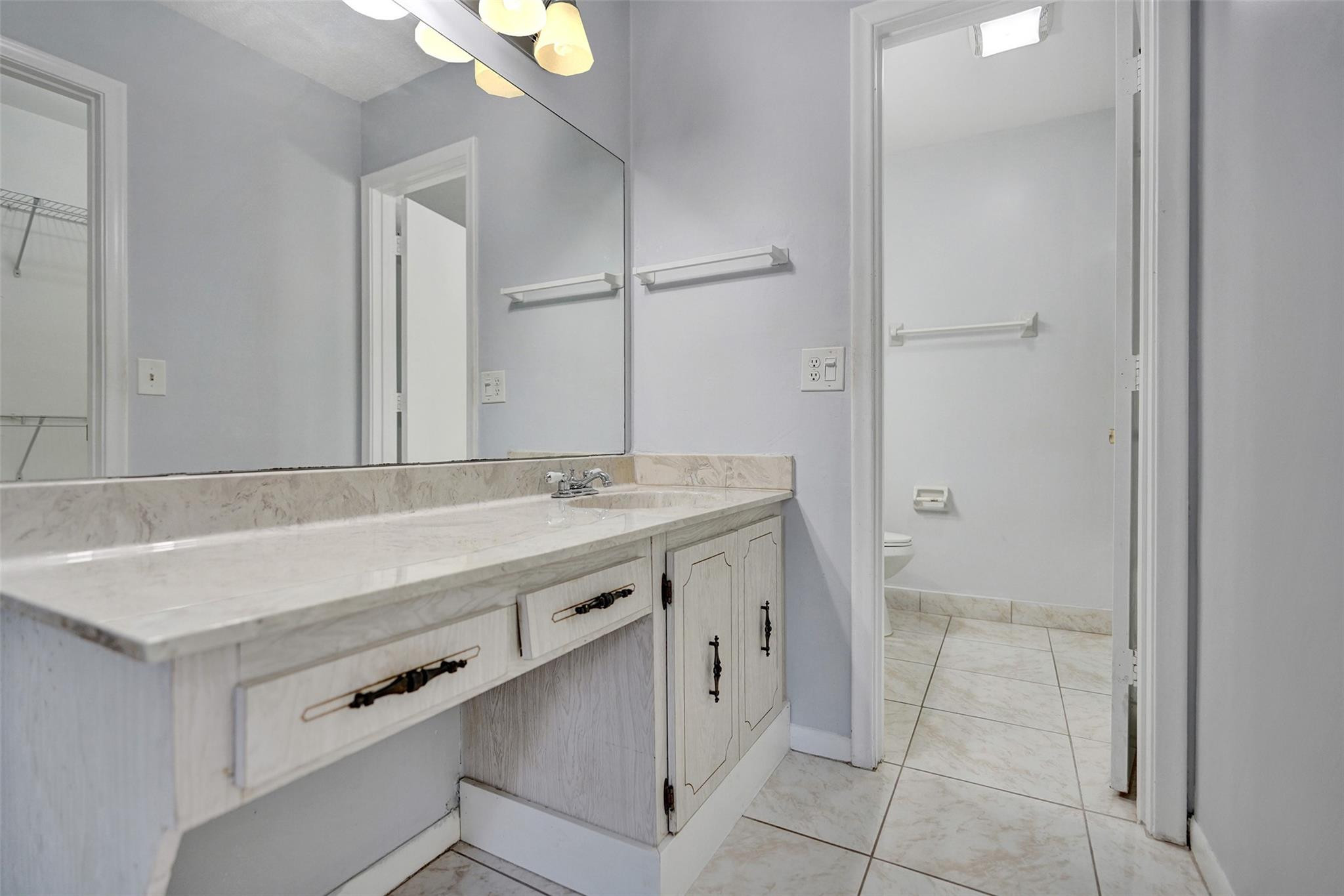 2380 Malayan Drive, Unit B Delray Beach, FL 33445 - Photo 27 of 35 a bathroom with a sink vanity and a mirror