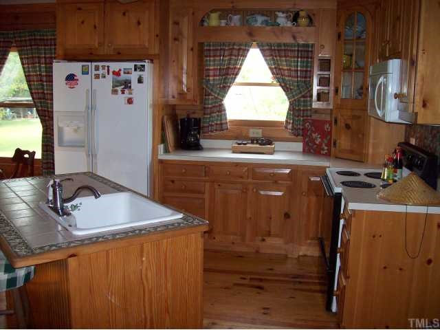 493 McGee Road Benson, NC 27504 - Photo 4 of 12 Custom made cabinets, center island with vegetable sink and bar, inlaid tile. Kitchen