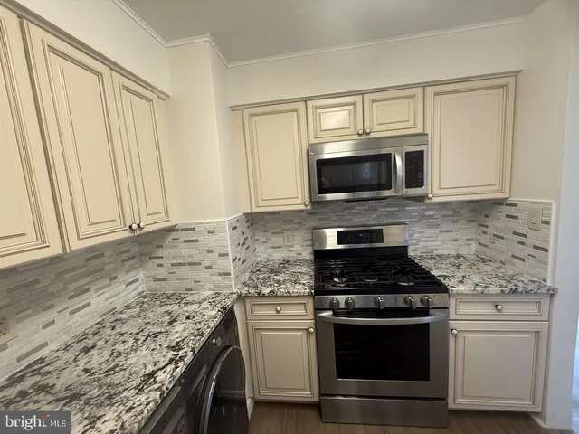 a kitchen with granite countertop a stove and a microwave