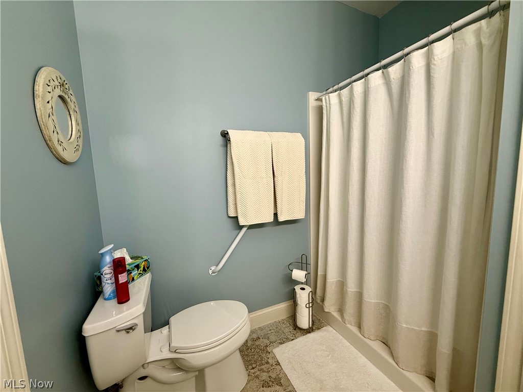 302 Wilcox Road Youngstown, OH 44515 - Photo 17 of 30 Bathroom featuring a white toilet, full shower enclosure, towel bar, and textured flooring