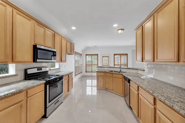 a kitchen with stainless steel appliances granite countertop a sink stove and microwave