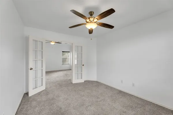 an empty room with closet and fan