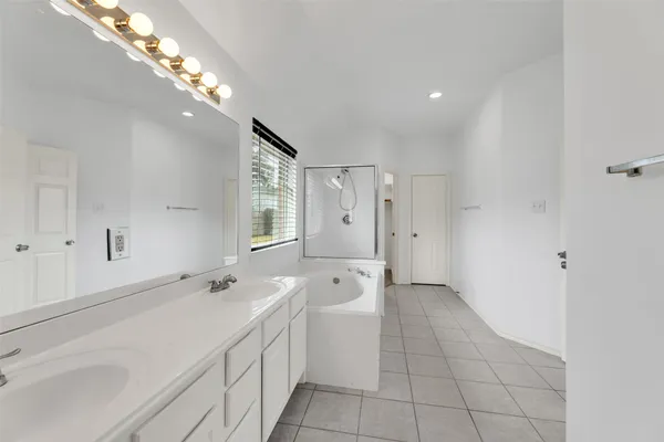 a spacious bathroom with a shower a sink and mirror