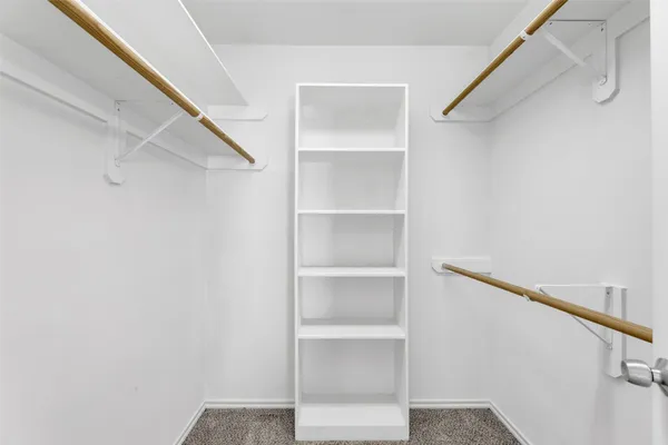 a view of walk in closet with empty racks