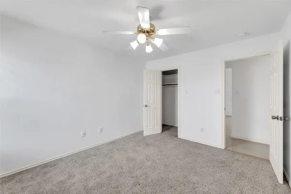 a view of an empty room with a chandelier fan