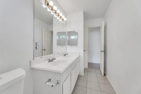 a spacious bathroom with a sink a toilet and a mirror