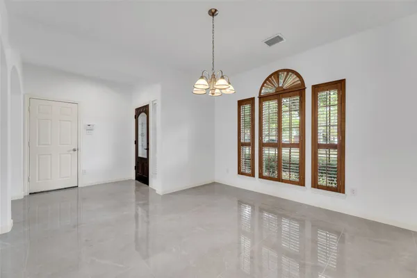 a view of an empty room with window and hallway