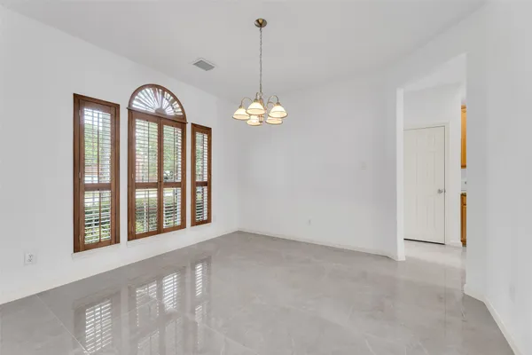 a view of an empty room with window and bathroom