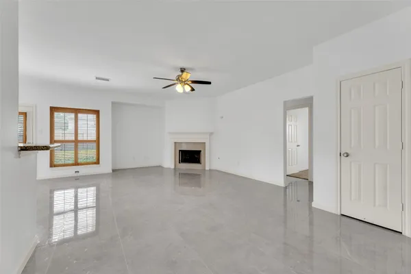an empty room with windows and ceiling fan
