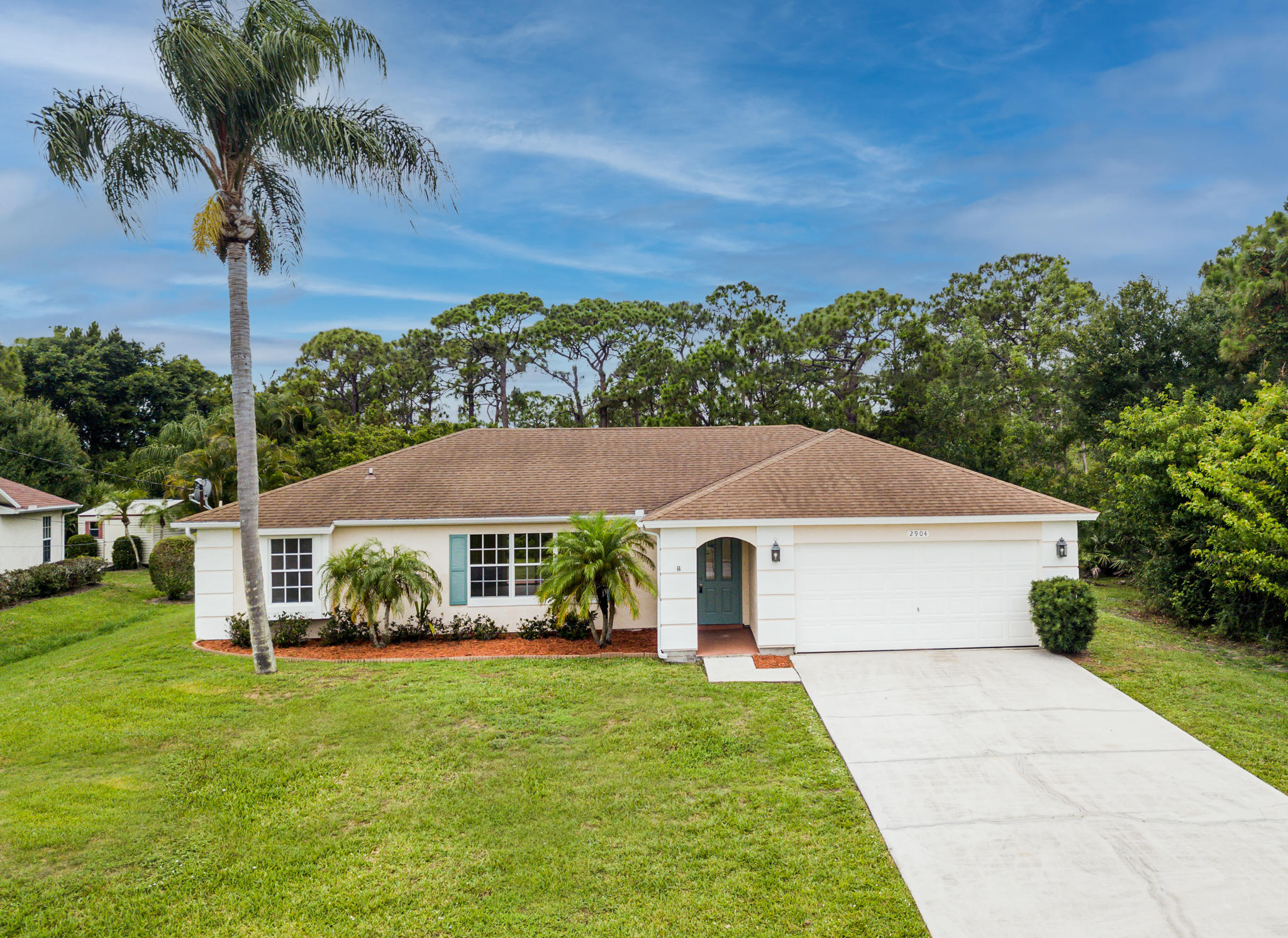 2904 Southeast Bella Road Port St. Lucie, FL 34984 - Photo 1 of 30 a front view of a house with a garden
