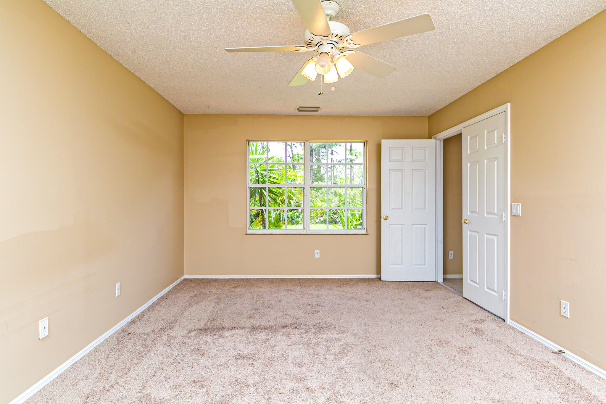 2904 Southeast Bella Road Port St. Lucie, FL 34984 - Photo 21 of 30 an empty room with windows and ceiling fan