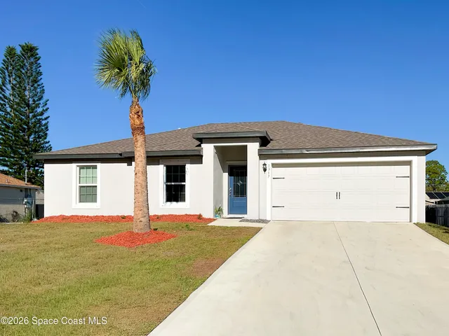 a view of a house with a yard and potted plants